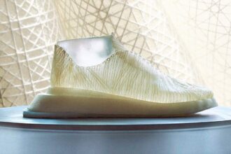 A shoe made of nanocellulose sits in front of a curtain.