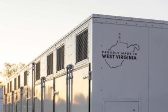A grid-scale battery stands against a clear sky.